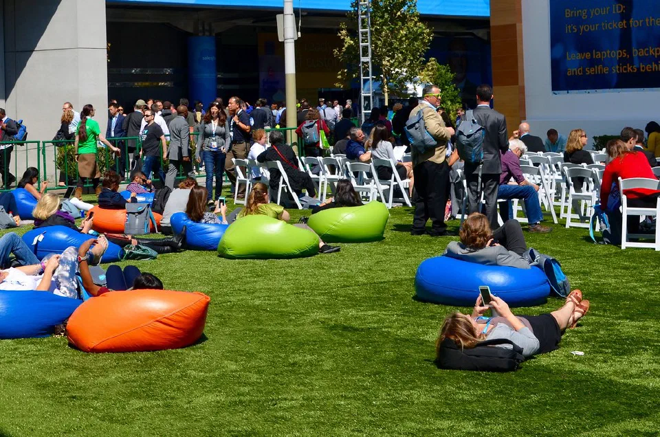 Dreamforce attendee checking a phone in a lounge area.