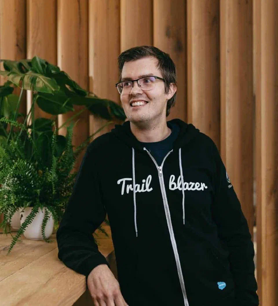 Thomas Theunen standing beside a wooden counter and plants in a Trailblazer hoodie.