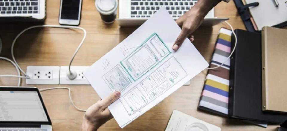 Illustration of a business analyst collaborating with stakeholders around a desk.